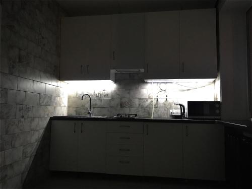 a kitchen with white cabinets and a sink and a window at Loft 2кімнатні Апартаменти Сучасний ремонт WiFi in Chernihiv