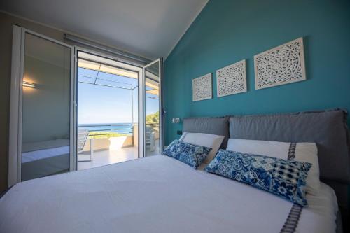 een slaapkamer met een bed met uitzicht op de oceaan bij Ilenia Seaview in Cefalù