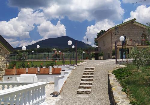 a row of white benches in front of a building at Locanda Arcadia in Picerno