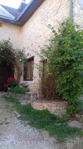 ein Backsteinhaus mit Busch neben einem Fenster in der Unterkunft petite maison au paradis in La Neuvelle-lès-Scey