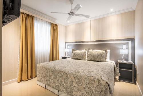a bedroom with a bed and a ceiling fan at Hotel Nuevo Ostende by bund in Mar del Plata