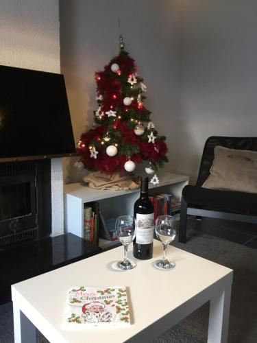 a christmas tree with a bottle of wine and two glasses at vakantiehuisje 007 in Koksijde