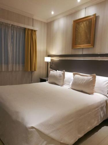 a large white bed in a hotel room at Hotel Nuevo Ostende by bund in Mar del Plata
