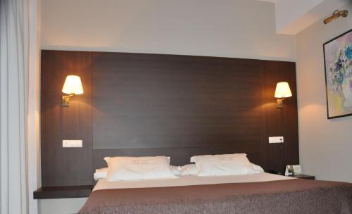 a bedroom with a large bed with a black headboard at Hotel Mendez Nuñez in Lugo