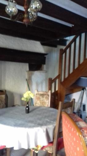 a dining room with a table and a staircase at petite maison au paradis in La Neuvelle-lès-Scey