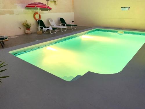 an indoor swimming pool with lights in a house at Classic Farmhouse & Private Pool in Mġarr