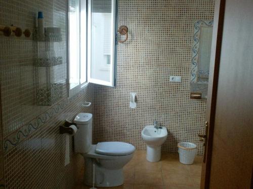 a bathroom with a toilet and a sink at Alojamiento Los Poetas in Baeza