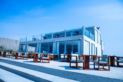 a row of chairs and tables in front of a building at Caravana Beach Resort Al Zorah in Ajman 