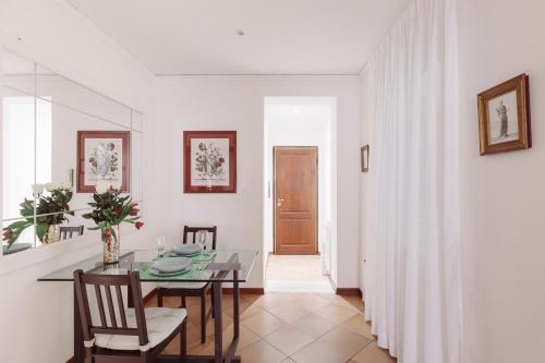 a room with a table, chairs, and a door at Relais Rasella 47 in Rome
