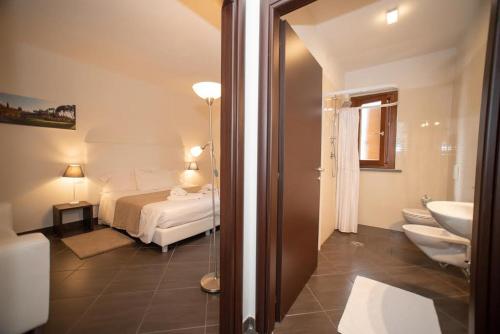 ein Schlafzimmer mit einem Bett und ein Badezimmer mit einem Waschbecken in der Unterkunft CONDOMINIO I GELSI in Arezzo