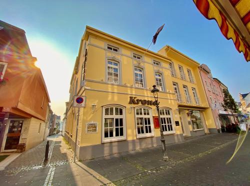 a yellow building on the side of a street at Das Hotel Krone in Königswinter