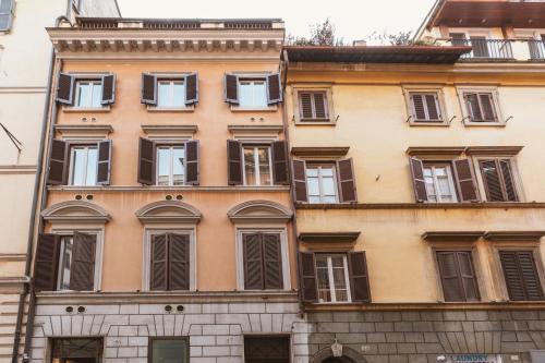 a building with two windows and a clock on the side of it at Relais Rasella 47 in Rome