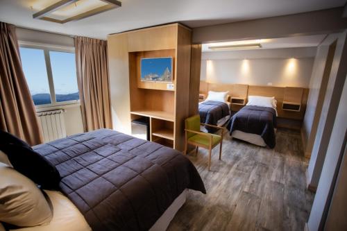 a hotel room with two beds and a desk at Hotel EcoSki by bund in San Carlos de Bariloche