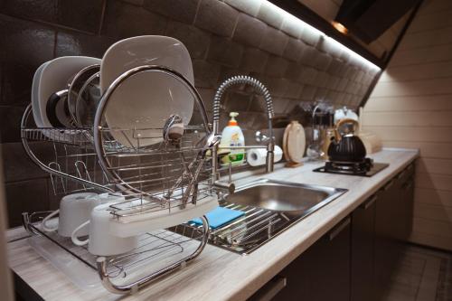 a dish drying rack next to a sink in a kitchen at Baza Otdikha Zolotoy Bereg in Zaporozhskoye