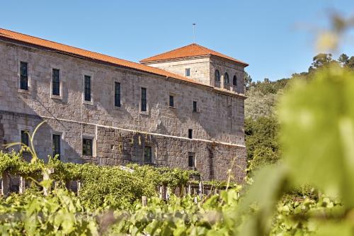 an old brick building with a tower on top of it at Eurostars Monumento Monasterio de San Clodio Hotel in Leiro