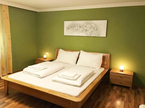 a bedroom with a bed with a green wall at Haus Schmitten – Austrian Alpine Getaways in Zell am See