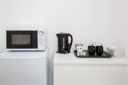 a microwave sitting on top of a white counter at Marina View Guest House in Irvine