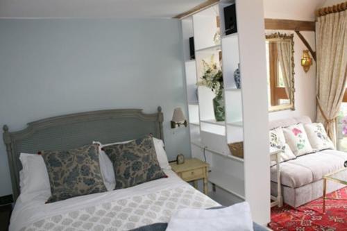 a bedroom with a bed and a couch at Remarkable 1-Bed Cottage near Henley-on-Thames in Henley on Thames