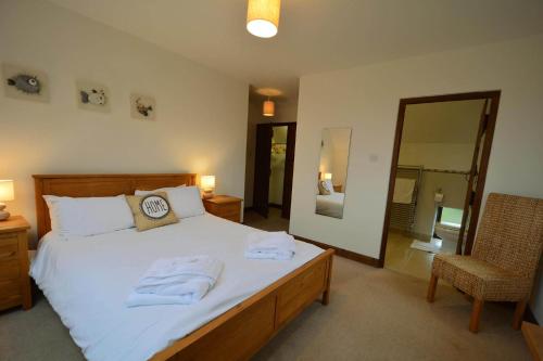 a bedroom with a large bed with towels on it at Harvest Moon in Payhembury