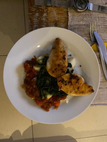 a white plate of food with a piece of food at Ndzuti Guest House in Witbank