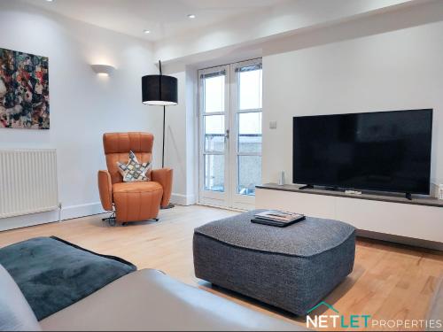 a living room with a large flat screen tv at Orion House - Luxury Apartment overlooking Milford Marina, Pembrokeshire in Milford Haven