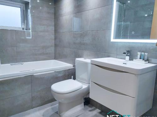 ein Badezimmer mit einer weißen Toilette und einem Waschbecken in der Unterkunft Orion House - Luxury Apartment overlooking Milford Marina, Pembrokeshire in Milford Haven