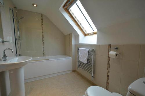 a bathroom with a sink toilet and a window at Hunters Moon in Payhembury