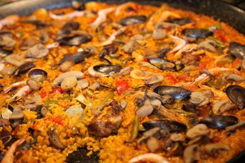 a pizza with mushrooms and rice in a pan at Hotel & Spa Peñiscola Palace in Peñíscola