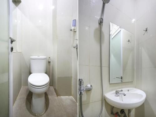 een witte badkamer met een toilet en een wastafel bij SUPER OYO Capital O 90056 Wisma Kebon Kacang 9 in Jakarta