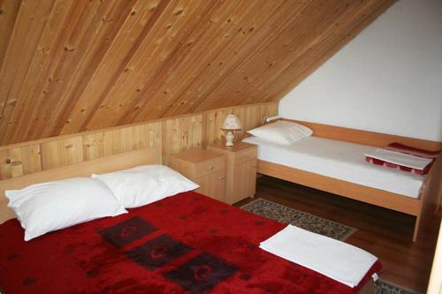 a bedroom with a bed and a wooden ceiling at Apartments Nino in Jasenak