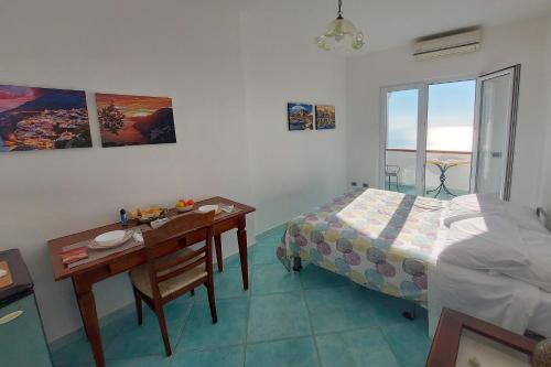 a bedroom with a bed and a desk and a table at Villa Casola B&B in Positano