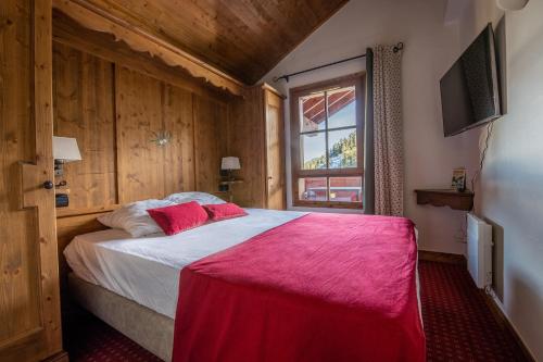 - une chambre avec un lit doté de draps rouges et une fenêtre dans l'établissement Appartement au centre du village ARC1950, 2 ou 4 personnes, à Arc 1950