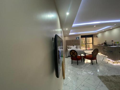 a room with a bed and a table and chairs at Trendy apartments in Entebbe