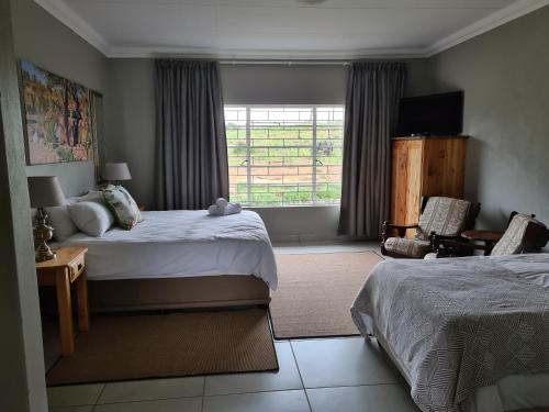a bedroom with two beds and a window at Forest Hill Country Lodge in Piet Retief