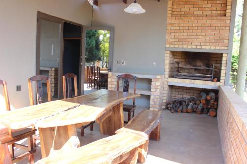un patio con mesas y sillas de madera y chimenea en Wilgeboomsdrift Safaris, en Modimolle