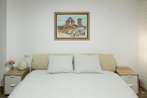 Una cama en un dormitorio con una foto encima. en Apartamento Avenida Principal I en Altea