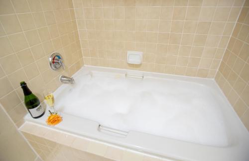 a white bath tub with a bottle of champagne at The Domain Hotel in Sunnyvale