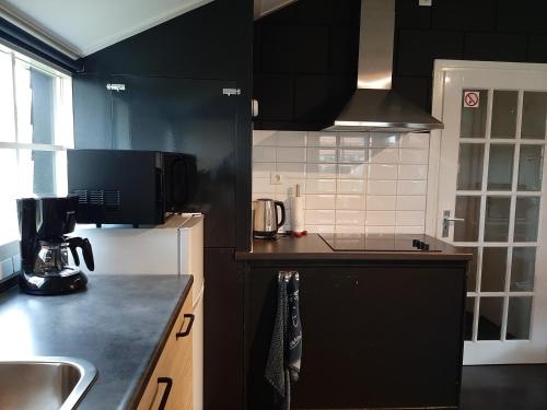 a kitchen with black cabinets and a black counter top at B&B Ebbenbroek in Bruchterveld
