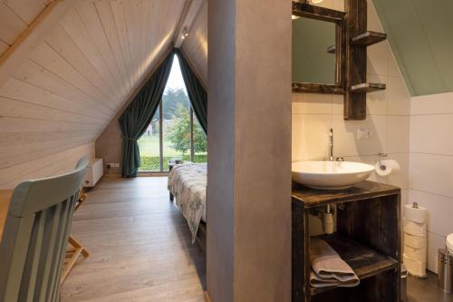 a bathroom with a sink and a bed in a room at Bosgasten in Putten