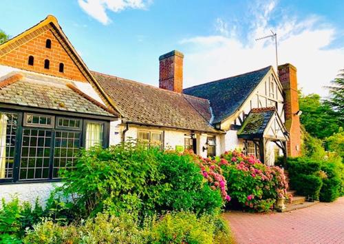a large white house with flowers in front of it at The Stanwick Hotel in Stanwick