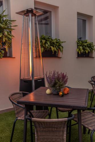 a wooden table with flowers and vegetables on a patio at Tailor Hotel Sport & Conference in Morąg