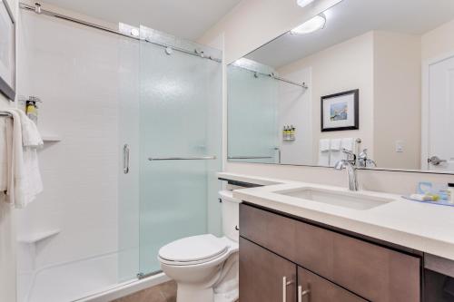 e bagno con doccia, servizi igienici e lavandino. di Candlewood Suites Eau Claire I-94, an IHG Hotel a Eau Claire
