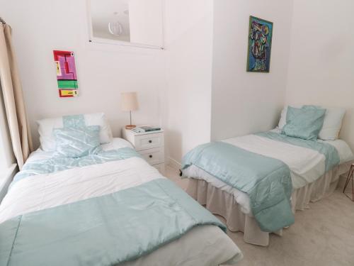 a bedroom with two beds with blue and white sheets at 1A Chantry Place in Morpeth