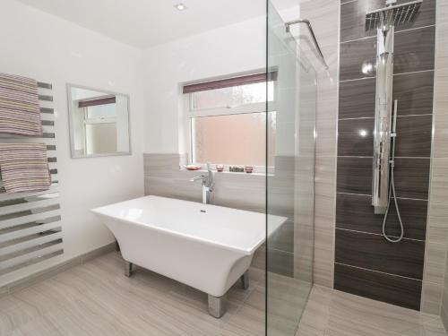 a bathroom with a white tub and a glass shower at 1A Chantry Place in Morpeth