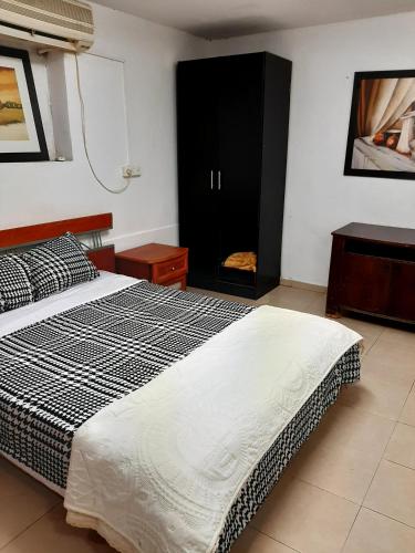 a bedroom with a bed and a black cabinet at Suite- Studio- Zimmer in Bet Sheʼan