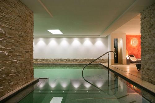 a swimming pool in the middle of a house at Hotel Medil in Campitello di Fassa