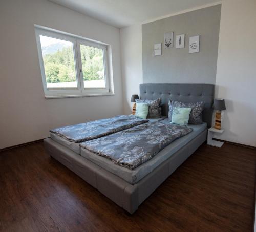ein großes Bett in einem Zimmer mit Fenster in der Unterkunft Ferienhaus Oberhof in Weissenbach am Lech