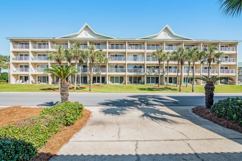 un grand bâtiment avec des palmiers devant lui dans l'établissement Maravilla, à Destin