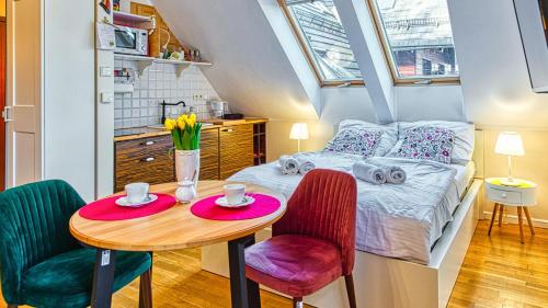 - une petite chambre avec un lit et une table avec deux chaises dans l'établissement Apartament z Sauną pod Świerkami - 5D Apartamenty, à Karpacz
