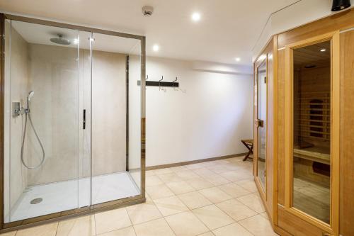 a bathroom with a shower with a glass door at Luxueuse et spacieuse villa avec sauna et piscine in Malmedy